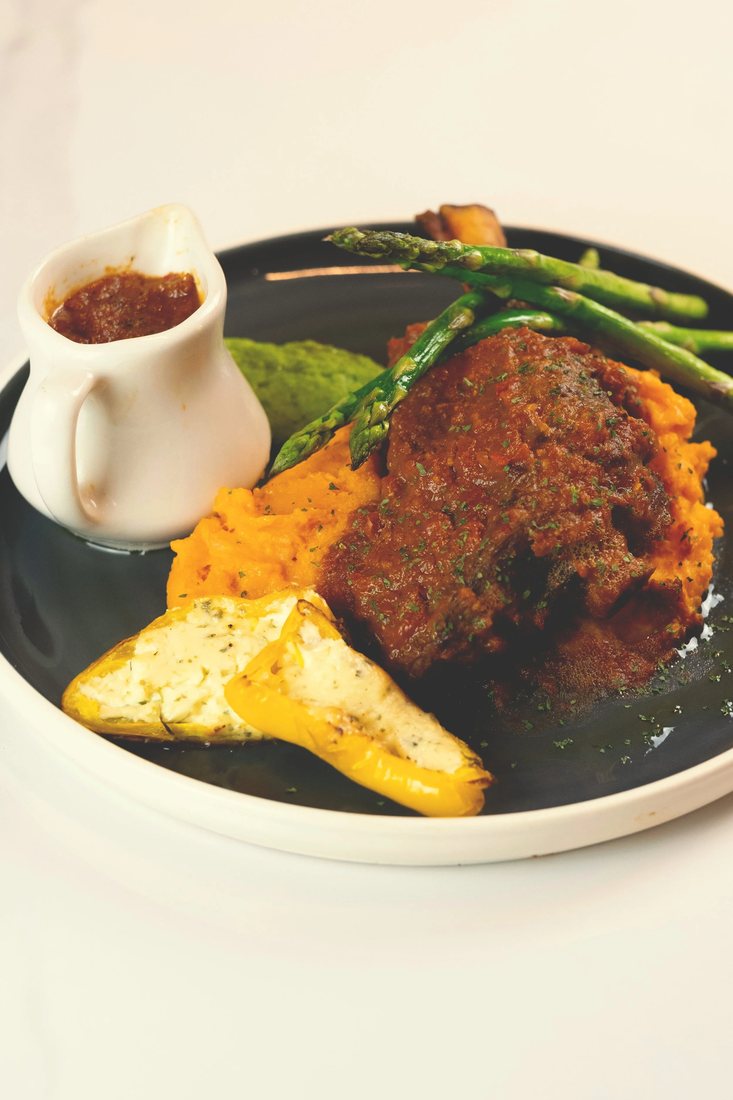 Australian Lamb Caldereta at Halina: braised lamb shank over carrot and potato mash with asparagus and a cheese-stuffed pepper